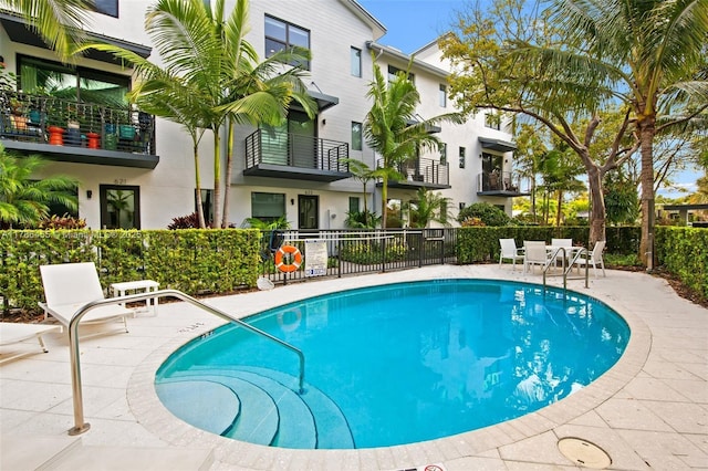 community pool featuring fence and a patio