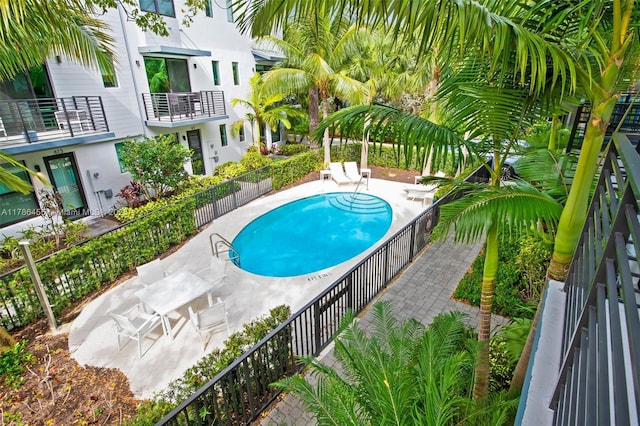 community pool featuring fence and a patio