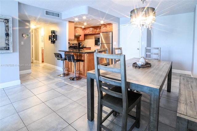 dining space with baseboards, an inviting chandelier, visible vents, and light tile patterned floors