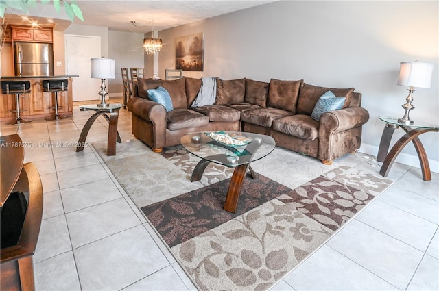 living room featuring a chandelier, baseboards, and light tile patterned floors