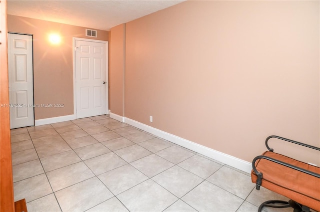 unfurnished bedroom with baseboards, visible vents, and light tile patterned flooring