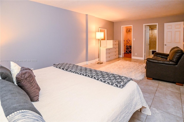 bedroom featuring a spacious closet, baseboards, a closet, and light tile patterned floors