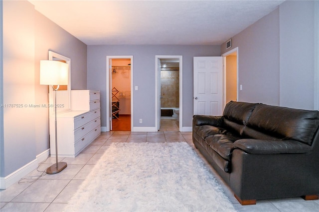 living area with baseboards, light tile patterned flooring, and visible vents