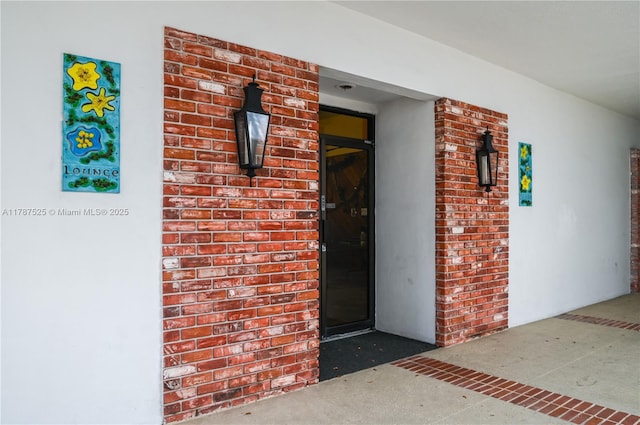 entrance to property with brick siding and stucco siding