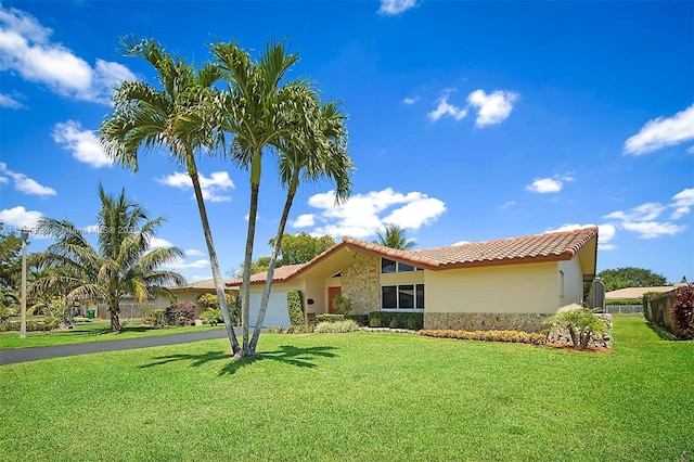 3971 NW 108th Dr, Coral Springs, FL 33065 - mediterranean / spanish home featuring a tile roof, a front lawn, aphalt driveway, a garage, and stucco siding