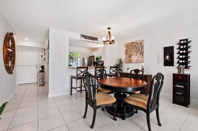 dining space with light tile patterned flooring, baseboards, and an inviting chandelier