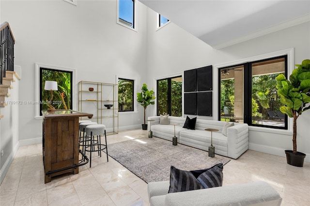 1672 Micanopy Ave, Miami, FL 33133 - living area featuring a towering ceiling, stairs, a dry bar, and crown molding