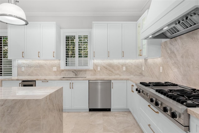 1672 Micanopy Ave, Miami, FL 33133 - kitchen with appliances with stainless steel finishes, custom range hood, ornamental molding, light stone counters, and white cabinets