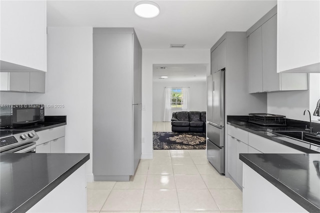 8350 SW 98 Th St, Miami, FL 33156 - kitchen featuring stainless steel appliances, a sink, dark countertops, visible vents, and gray cabinetry