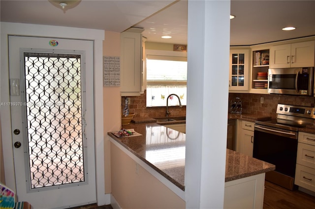 9681 Sunrise Lakes Blvd Unit 209, Sunrise, FL 33322 - kitchen featuring backsplash, dark stone countertops, stainless steel appliances, and a sink