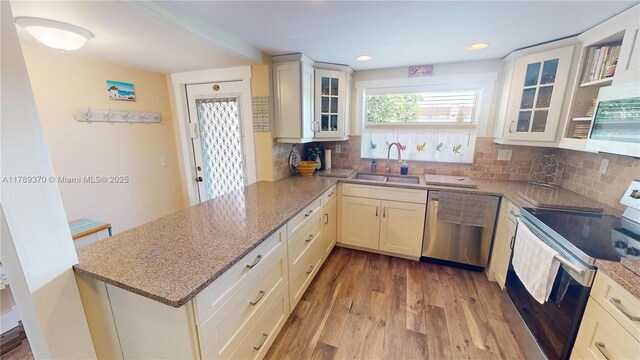9681 Sunrise Lakes Blvd Unit 209, Sunrise, FL 33322 - kitchen featuring stainless steel appliances, a peninsula, a sink, and light stone counters