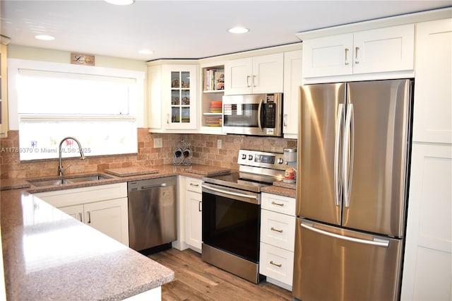 9681 Sunrise Lakes Blvd Unit 209, Sunrise, FL 33322 - kitchen with a sink, backsplash, white cabinetry, glass insert cabinets, and appliances with stainless steel finishes