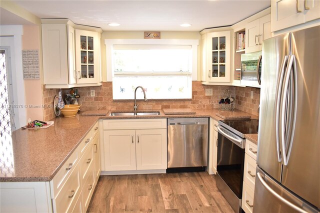 9681 Sunrise Lakes Blvd Unit 209, Sunrise, FL 33322 - kitchen with light stone counters, a sink, decorative backsplash, light wood-type flooring, and appliances with stainless steel finishes
