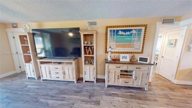 9681 Sunrise Lakes Blvd Unit 209, Sunrise, FL 33322 - living area with wood finished floors, visible vents, and a textured ceiling