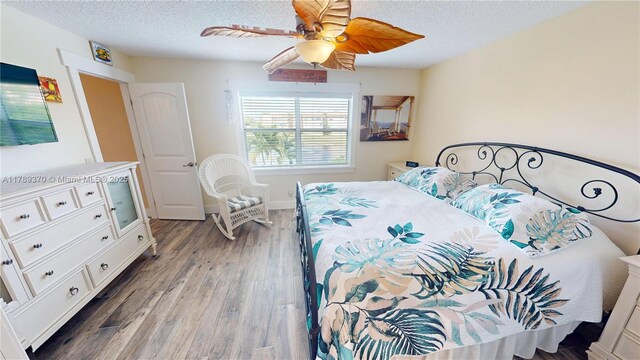 9681 Sunrise Lakes Blvd Unit 209, Sunrise, FL 33322 - bedroom featuring wood finished floors, a textured ceiling, and ceiling fan