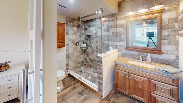 9681 Sunrise Lakes Blvd Unit 209, Sunrise, FL 33322 - bathroom featuring toilet, wood finished floors, a shower stall, ceiling fan, and vanity