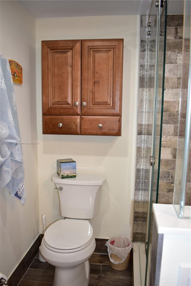 9681 Sunrise Lakes Blvd Unit 209, Sunrise, FL 33322 - bathroom with wood finished floors, toilet, baseboards, and a stall shower