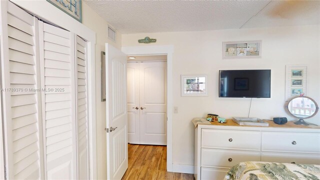 9681 Sunrise Lakes Blvd Unit 209, Sunrise, FL 33322 - bedroom with visible vents, a textured ceiling, and light wood-style floors