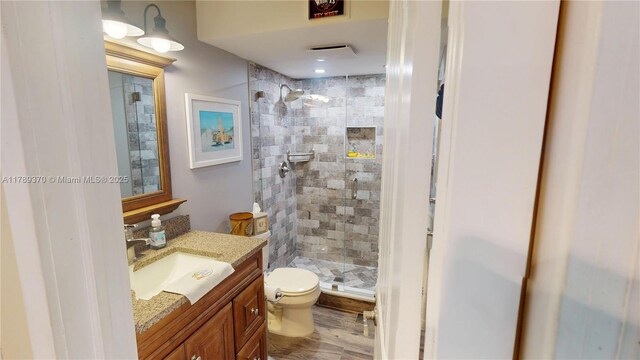 9681 Sunrise Lakes Blvd Unit 209, Sunrise, FL 33322 - bathroom featuring wood finished floors, vanity, toilet, and a stall shower