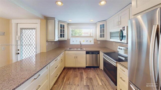 9681 Sunrise Lakes Blvd Unit 209, Sunrise, FL 33322 - kitchen with light stone counters, a sink, light wood-style flooring, appliances with stainless steel finishes, and recessed lighting