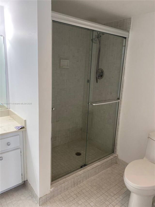 17600 N Bay Rd Unit N607, Sunny Isles Beach, FL 33160 - full bathroom featuring vanity, tile patterned flooring, a stall shower, and toilet