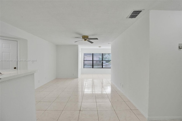 unfurnished room featuring visible vents, light tile patterned floors, ceiling fan, and a textured ceiling
