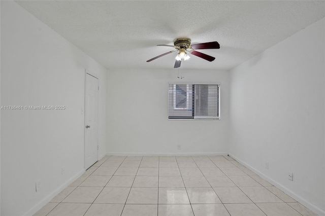 unfurnished room with baseboards, a ceiling fan, and a textured ceiling