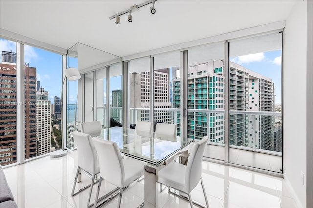 tiled dining space with a wall of windows and a healthy amount of sunlight