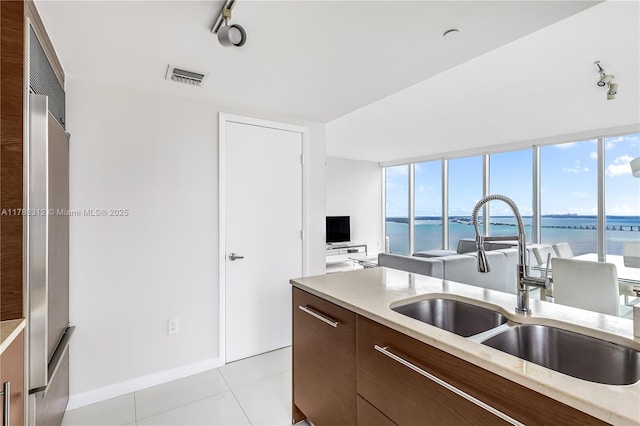 kitchen featuring light countertops, rail lighting, visible vents, a sink, and modern cabinets