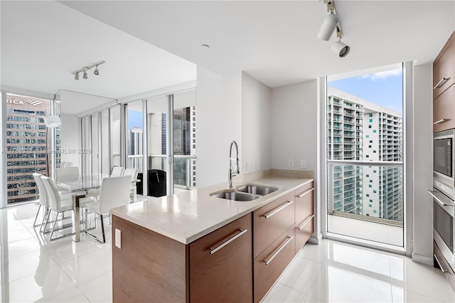 kitchen featuring modern cabinets, rail lighting, light tile patterned flooring, and a sink