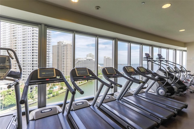 workout area with recessed lighting, a city view, and plenty of natural light