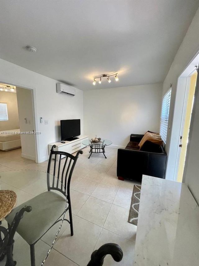 living room with light tile patterned flooring, an AC wall unit, and baseboards