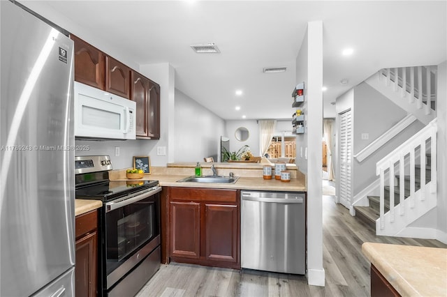 kitchen with light wood finished floors, visible vents, appliances with stainless steel finishes, and a sink