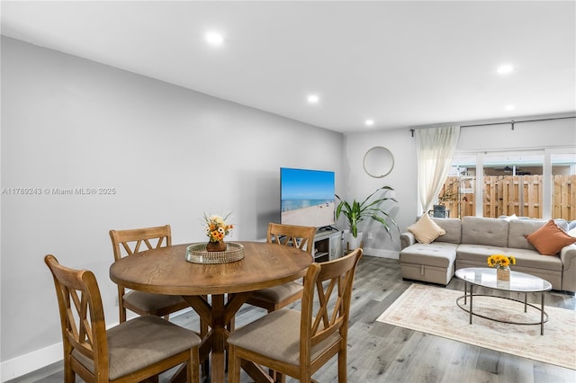 dining space with baseboards, wood finished floors, and recessed lighting