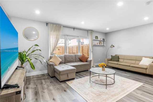 living room featuring baseboards, light wood-style floors, and recessed lighting