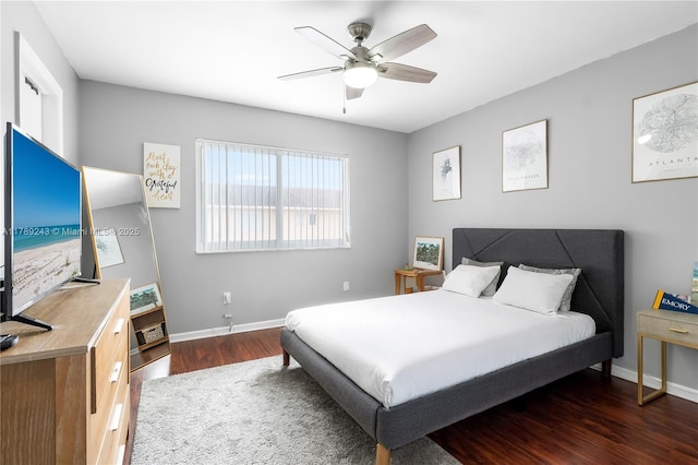 bedroom with ceiling fan, baseboards, and wood finished floors