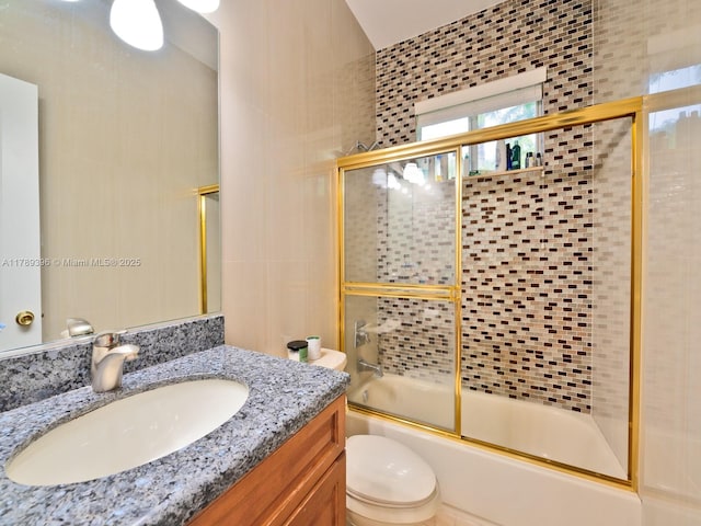 bathroom with combined bath / shower with glass door, vanity, and toilet