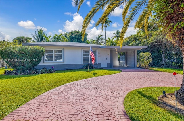 2020 NW 33rd Ct, Oakland Park, FL 33309 - ranch-style home with a carport, a front yard, and curved driveway