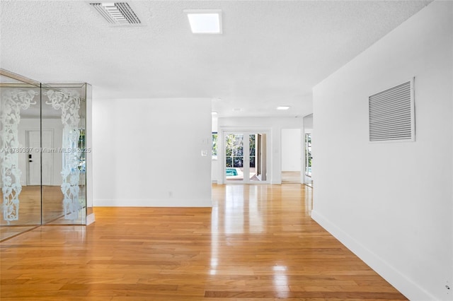 2020 NW 33rd Ct, Oakland Park, FL 33309 - interior space with light wood-type flooring, a textured ceiling, baseboards, and visible vents
