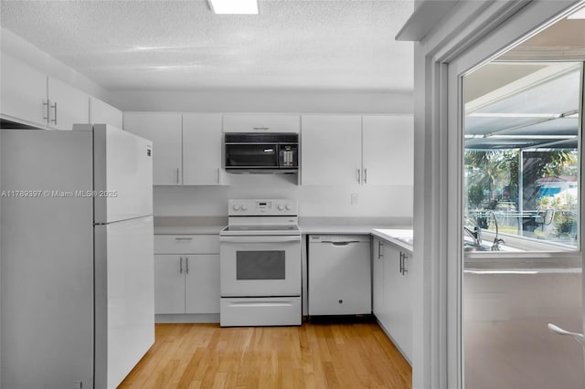 2020 NW 33rd Ct, Oakland Park, FL 33309 - kitchen with white cabinets, light countertops, and white appliances