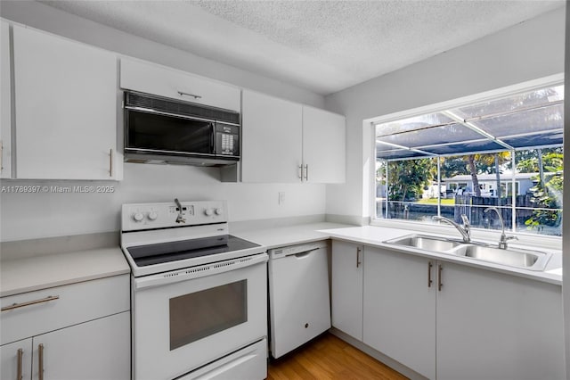 2020 NW 33rd Ct, Oakland Park, FL 33309 - kitchen featuring light countertops, white appliances, a sink, and white cabinetry