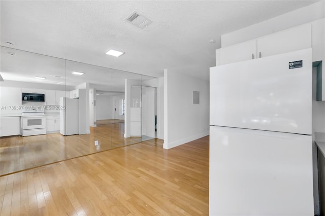2020 NW 33rd Ct, Oakland Park, FL 33309 - kitchen featuring white cabinets, visible vents, light wood-style floors, and white appliances
