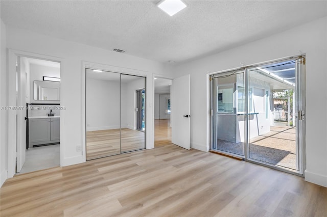 2020 NW 33rd Ct, Oakland Park, FL 33309 - unfurnished bedroom with access to exterior, visible vents, light wood-type flooring, baseboards, and a textured ceiling