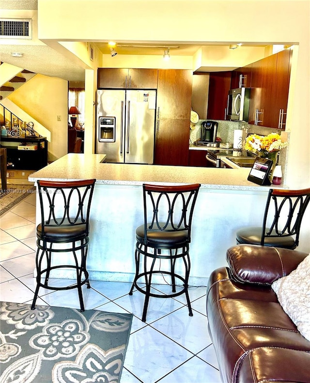 2554 N 38th Ave Unit C-26, Hollywood, FL 33021 - kitchen with appliances with stainless steel finishes, a peninsula, light countertops, and a breakfast bar