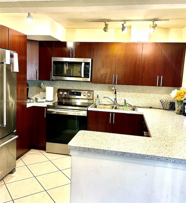 2554 N 38th Ave Unit C-26, Hollywood, FL 33021 - kitchen with appliances with stainless steel finishes, backsplash, track lighting, light tile patterned flooring, and light stone countertops