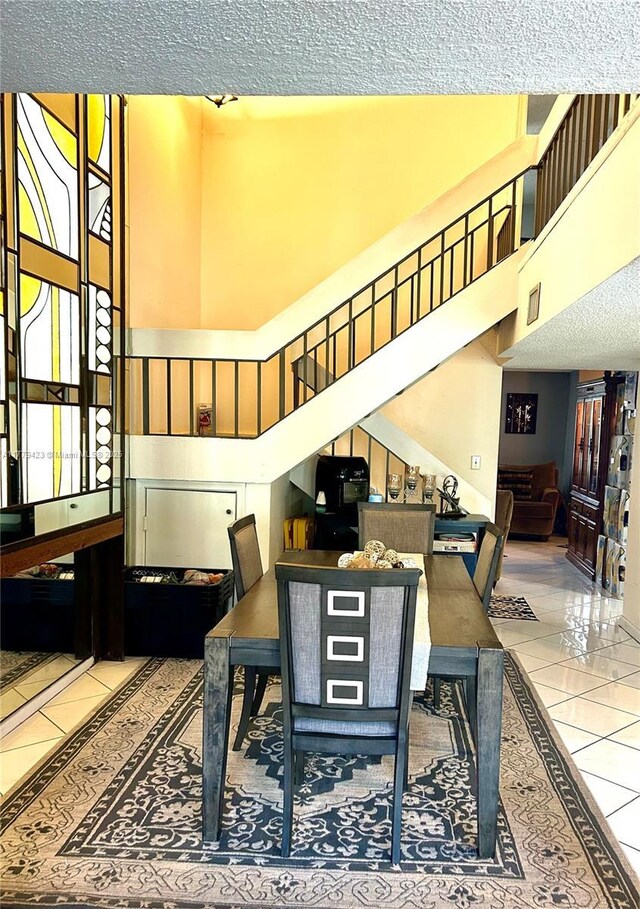 2554 N 38th Ave Unit C-26, Hollywood, FL 33021 - tiled dining room with stairs, a textured ceiling, and a high ceiling
