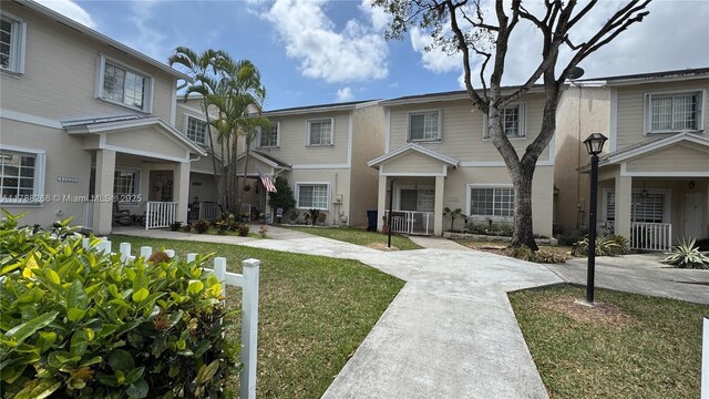 12222 SW 148th St, Miami, FL 33186 - view of property featuring a porch, a front lawn, and stucco siding