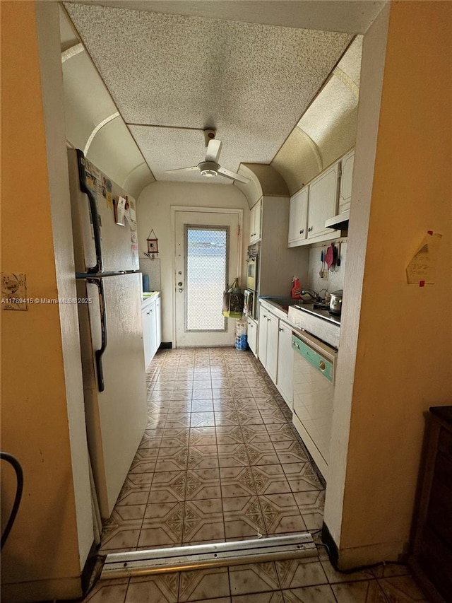 kitchen featuring freestanding refrigerator, white cabinetry, a ceiling fan, dishwashing machine, and light tile patterned floors