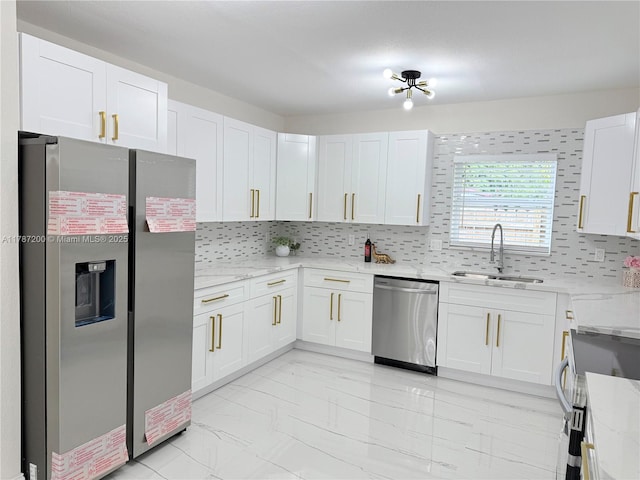 kitchen with light stone countertops, marble finish floor, a sink, and appliances with stainless steel finishes