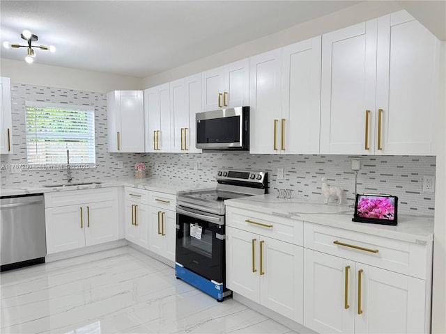 kitchen featuring marble finish floor, backsplash, a sink, appliances with stainless steel finishes, and white cabinetry